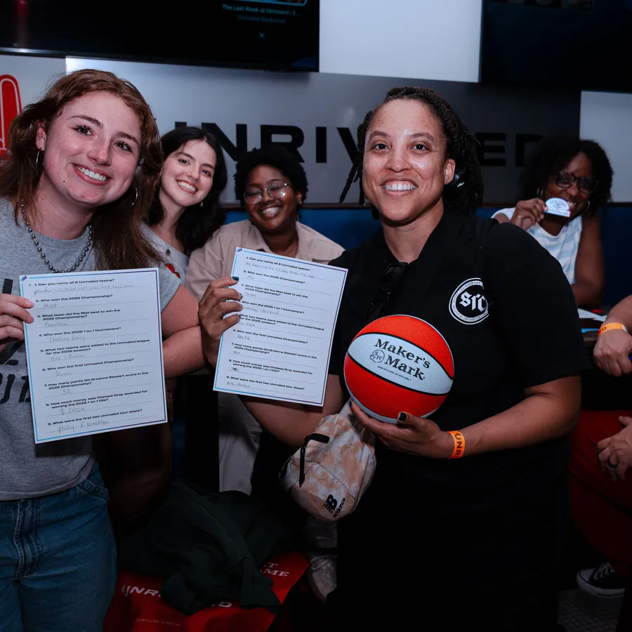 Trivia answer sheets held high, Maker’s Mark ball in hand