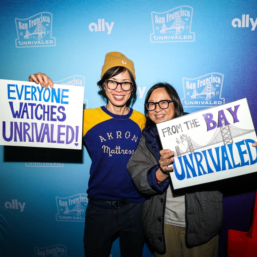 Handmade signs held up in front of the San Francisco is Unrivaled backdrop